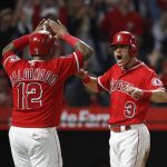 Los Angeles Angels' Ian Kinsler, right, and Martin Maldonado celebrate after they scored on a single by Mike Trout during the fifth inning of the team's baseball game against the Arizona Diamondbacks, Tuesday, June 19, 2018, in Anaheim, Calif. (AP Photo/Jae C. Hong)