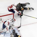 Vegas Golden Knights left wing William Carrier, upper right, falls as he tries to shoot while under pressure from Washington Capitals defenseman Christian Djoos, upper left, of Sweden, while Capitals goaltender Braden Holtby, left, sits in goal and Golden Knights left wing Tomas Nosek watches during the first period in Game 5 of the NHL hockey Stanley Cup Finals on Thursday, June 7, 2018, in Las Vegas. (AP Photo/John Locher)