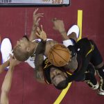 Cleveland Cavaliers' LeBron James shoots over Golden State Warriors forward David West during the first half of Game 4 of basketball's NBA Finals, Friday, June 8, 2018, in Cleveland. (AP Photo/Carlos Osorio, Pool)