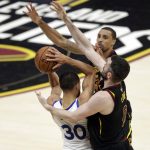 Golden State Warriors' Stephen Curry is defended by Cleveland Cavaliers' George Hill, rear, and Kevin Love during the first half of Game 4 of basketball's NBA Finals, Friday, June 8, 2018, in Cleveland. (AP Photo/Tony Dejak)