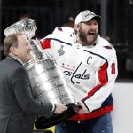 Washington Capitals left wing Alex Ovechkin, right, of Russia, celebrates as he takes the Stanley Cup from NHL commissioner Gary Bettman after the Capitals defeated the Golden Knights 4-3 in Game 5 of the NHL hockey Stanley Cup Finals Thursday, June 7, 2018, in Las Vegas. (AP Photo/John Locher)