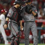 Arizona Diamondbacks relief pitcher Yoshihisa Hirano, right, of Japan, talks to catcher Jeff Mathis during the seventh inning of a baseball game against the Los Angeles Angels, Monday, June 18, 2018, in Anaheim, Calif. (AP Photo/Jae C. Hong)