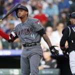 Arizona Diamondbacks' Ketel Marte, left, reacts after striking out as Colorado Rockies catcher Chris Iannetta heads back to the dugout to end the top of the first inning of a baseball game Friday, June 8, 2018, in Denver. (AP Photo/David Zalubowski)