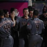 Arizona Diamondbacks' Nick Ahmed, center, is greeted by teammates in the dugout after hitting a home run during the eighth inning of a baseball game against the Los Angeles Angels, Monday, June 18, 2018, in Anaheim, Calif. (AP Photo/Jae C. Hong)
