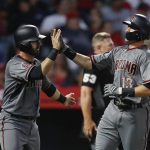 Arizona Diamondbacks' Nick Ahmed, right, and Daniel Descalso celebrate after they scored on a double hit by Jeff Mathis during the fourth inning of a baseball game against the Los Angeles Angels, Monday, June 18, 2018, in Anaheim, Calif. (AP Photo/Jae C. Hong)
