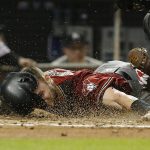 Arizona Diamondbacks' Chris Owings dives into home as Miami Marlins catcher Bryan Holaday tags him out during the fifth inning of a baseball game Wednesday, June 27, 2018, in Miami. (AP Photo/Wilfredo Lee)