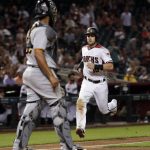 Arizona Diamondbacks' Chris Owings scores on a base hit by teammate Nick Ahmed during the seventh inning of a baseball game as Pittsburgh Pirates catcher Elias Diaz watches, Monday, June 11, 2018, in Phoenix. (AP Photo/Matt York)