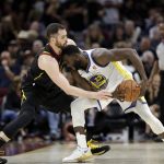 Golden State Warriors' Draymond Green is defended by Cleveland Cavaliers' Kevin Love during the second half of Game 4 of basketball's NBA Finals, Friday, June 8, 2018, in Cleveland. (AP Photo/Tony Dejak)
