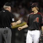 Umpire Ted Barrett (65) inspects the baseball with Arizona Diamondbacks pitcher Zack Greinke, right, after a foul ball in the fourth inning of a baseball game against the Miami Marlins, Saturday, June 2, 2018, in Phoenix. (AP Photo/Rick Scuteri)