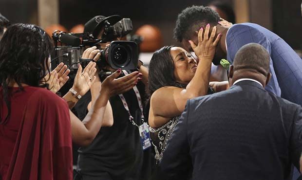Arizona's Deandre Ayton, top right, is congratulated by friends and family after he was picked firs...
