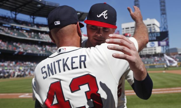 Atlanta Braves starting pitcher Sean Newcomb, right, hugs manager Brian Snitker (43) after defeatin...