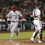 St. Louis Cardinals' Yadier Molina (4) scores a run as Arizona Diamondbacks catcher Jeff Mathis, right, watches for the baseball during the second inning of a baseball game Tuesday, July 3, 2018, in Phoenix. (AP Photo/Ross D. Franklin)