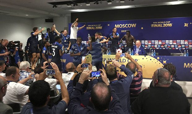 French players celebrate after bursting into a press conference by France head coach Didier Descham...
