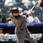 Arizona Diamondbacks' A.J. Pollock follows through with his swing after connecting for an RBI-single off Colorado Rockies starting pitcher Kyle Freeland in the first inning of a baseball game Thursday, July 12, 2018, in Denver. (AP Photo/David Zalubowski)
