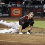 Arizona Diamondbacks' Paul Goldschmidt loses his helmet as he slide across home plate to score against the Colorado Rockies on a sacrifice fly by Nick Ahmed during the fourth inning of a baseball game Saturday, July 21, 2018, in Phoenix. (AP Photo/Ralph Freso)