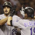 Colorado Rockies' Nolan Arenado gets a high-five from Charlie Blackmon after hitting a two-run home run off Arizona Diamondbacks' Robbie Ray during the first inning of a baseball game Friday, July 20, 2018, in Phoenix. (AP Photo/Darryl Webb)