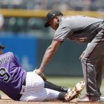 Arizona Diamondbacks shortstop Ketel Marte, right, tags out Colorado Rockies' DJ LeMahieu as he tries to advance to second base on a ground ball hit by Charlie Blackmon in the first inning of a baseball game Thursday, July 12, 2018, in Denver. (AP Photo/David Zalubowski)