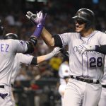 Colorado Rockies' Nolan Arenado gets a high-five from Carlos Gonzalez after hitting his second two-run home run of the night against the Arizona Diamondbacks, during the fifth inning of a baseball game Friday, July 20, 2018, in Phoenix. (AP Photo/Darryl Webb)