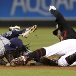 Arizona Diamondbacks' Jarrod Dyson, right, beats the tag by San Diego Padres shortstop Freddy Galvis after hitting a double during the first inning during a baseball game Saturday, July 7, 2018, in Phoenix. (AP Photo/Rick Scuteri)