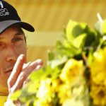 Britain's Geraint Thomas, wearing the overall leader's yellow jersey, throws his flowers to his wife Sarah Elen on the podium after the twentieth stage of the Tour de France cycling race, an individual time trial over 31 kilometers (19.3 miles)with start in Saint-Pee-sur-Nivelle and finish in Espelette, France, Saturday July 28, 2018. (AP Photo/Peter Dejong)