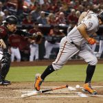 San Francisco Giants' Derek Holland, right, runs to first after making accidental contact with the ball as Arizona Diamondbacks catcher John Ryan Murphy, left, runs to the ball to start a double play during the second inning of a baseball game Sunday, July 1, 2018, in Phoenix. (AP Photo/Ross D. Franklin)
