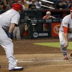 St. Louis Cardinals' Jedd Gyorko, right, pauses at home plate after being tagged out trying to score a run as Yadier Molina (4) looks on during the first inning of a baseball game against the Arizona Diamondbacks Monday, July 2, 2018, in Phoenix. (AP Photo/Ross D. Franklin)