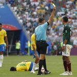 Referee Gianluca Rocchi from Italy shows the yellow card to Mexico's Edson Alvarez for fouling Brazil's Neymar during the round of 16 match between Brazil and Mexico at the 2018 soccer World Cup in the Samara Arena, in Samara, Russia, Monday, July 2, 2018. (AP Photo/Eduardo Verdugo)