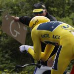 A spectator holds a sign with a "G" as Britain's Geraint Thomas, wearing the overall leader's yellow jersey, passes during the twentieth stage of the Tour de France cycling race, an individual time trial over 31 kilometers (19.3 miles)with start in Saint-Pee-sur-Nivelle and finish in Espelette, France, Saturday July 28, 2018. (AP Photo/Peter Dejong)