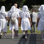 Nuns leave after watching the cyclists prior to the nineteenth stage of the Tour de France cycling race over 200.5 kilometers (124.6 miles) with start in Lourdes and finish in Laruns, France, Friday July 27, 2018. (AP Photo/Christophe Ena )
