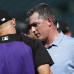 Colorado Rockies general manager Jeff Bridich, right, confers with shortstop Pat Valaika behind the batting cage as the Rockies warmed up before a baseball game against the Arizona Diamondbacks on Tuesday, July 10, 2018, in Denver. (AP Photo/David Zalubowski)