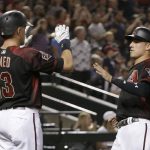 Arizona Diamondbacks Jake Lamb celebrates with Nick Ahmed (13) after scoring a run on a double by Daniel Descalso during the first inning during a baseball game against the San Diego Padres, Saturday, July 7, 2018, in Phoenix. (AP Photo/Rick Scuteri)