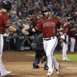 Arizona Diamondbacks' Daniel Descalso (3) is congratulated by Jake Lamb (22) after scoring a run against the Colorado Rockies on a triple by teammate Nick Ahmed during the fourth inning of a baseball game, Sunday, July 22, 2018, in Phoenix. (AP Photo/Ralph Freso)