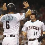 Arizona Diamondbacks' A.J. Pollack is greeted at home plate by teammate David Peralta after scoring against the Colorado Rockies during the first inning of a baseball game Friday, July 20, 2018, in Phoenix. (AP Photo/Darryl Webb)