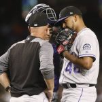 Colorado Rockies pitcher German Marquez and catcher Tony Wolters talk with pitching coach Steve Foster during the first inning against the Arizona Diamondbacks in a baseball game Friday, July 20, 2018, in Phoenix. The Diamondbacks scored three runs in the first inning. (AP Photo/Darryl Webb)