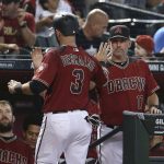 Arizona Diamondbacks' Daniel Descalso (3) is congratulated by manager Torey Lovullo (17) after scoring against the Colorado Rockies on a triple by teammate Nick Ahmed during the fourth inning of a baseball game, Sunday, July 22, 2018, in Phoenix. (AP Photo/Ralph Freso)