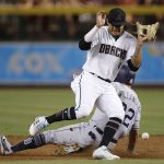 Arizona Diamondbacks shortstop Ketel Marte, front, cannot find the baseball as San Diego Padres' Christian Villanueva, back, steals second base during the first inning of a baseball game Friday, July 6, 2018, in Phoenix. (AP Photo/Ross D. Franklin)