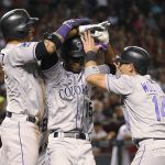 Colorado Rockies' Raimel Tapia (15) is greeted by Carlos Gonzalez, left, and Tony Wolters after hitting a grand slam off Arizona Diamondbacks' Archie Bradley durkng the seventh inning of a baseball game Friday, July 20, 2018, in Phoenix. (AP Photo/Darryl Webb)