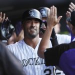 Colorado Rockies' Ian Desmond, center, is congratulated by teammates as he returns to the dugout after hitting a three-run home run off Arizona Diamondbacks starting pitcher Shelby Miller during the first inning of a baseball game Wednesday, July 11, 2018, in Denver. (AP Photo/David Zalubowski)