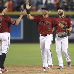 Arizona Diamondbacks' David Peralta (6) and Steven Souza, right, are congratulated by teammate Nick Ahmed (13) following a victory over the Colorado Rockies in a baseball game, Sunday, July 22, 2018, in Phoenix. (AP Photo/Ralph Freso)