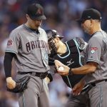 Arizona Diamondbacks starting pitcher Patrick Corbin, left, hands the ball to manager Torey Lovullo as catcher Jeff Mathis pats Corbin, who had given up a double to Colorado Rockies' Trevor Story during the fifth inning of a baseball game Tuesday, July 10, 2018, in Denver. (AP Photo/David Zalubowski)
