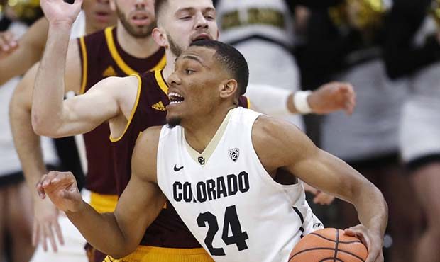 Colorado guard George King, front, drives past Arizona State guard Kodi Justice during the first ha...