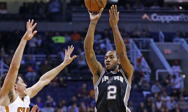 San Antonio Spurs forward Kawhi Leonard (2) shoots over Phoenix Suns guard Devin Booker, left, duri...