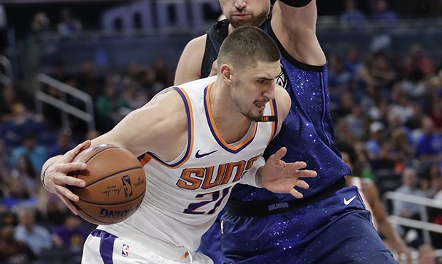 Phoenix Suns' Alex Len, left, makes a move to get to the basket against Orlando Magic's Nikola Vuce...