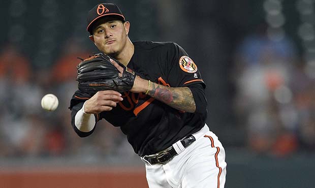 Baltimore Orioles shortstop Manny Machado throws to first for the out on New York Yankees' Giancarl...
