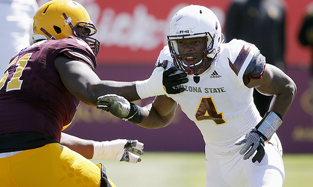 Arizona State offensive lineman Zach Robertson, left, puts an arm out to block Arizona State defens...
