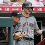 Arizona Diamondbacks manager Torey Lovullo, left, and Nick Ahmed (13) stand in the dugout in the eighth inning of a baseball game against the Cincinnati Reds, Sunday, Aug. 12, 2018, in Cincinnati. (AP Photo/John Minchillo)