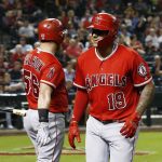Los Angeles Angels' Jefry Marte (19) heads back to the dugout after celebrating his home run against the Arizona Diamondbacks with Kole Calhoun (56) during the seventh inning of a baseball game Tuesday, Aug. 21, 2018, in Phoenix. (AP Photo/Ross D. Franklin)