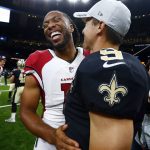 Arizona Cardinals wide receiver Larry Fitzgerald laughs with New Orleans Saints quarterback Drew Brees (9) in the second half of an NFL preseason football game in New Orleans, Friday, Aug. 17, 2018. The Cardinals won 20-15. (AP Photo/Butch Dill)