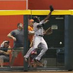 San Francisco Giants center fielder Andrew McCutchen crashes into the fence as he jumps in vain for a home run hit by Arizona Diamondbacks' Paul Goldschmidt during the first inning of a baseball game Friday, Aug. 3, 2018, in Phoenix. (AP Photo/Ross D. Franklin)
