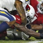 Arizona Cardinals running back Chase Edmonds stretches the football across the goal line for a touchdown as Los Angeles Chargers linebacker Kyzir White, left, defends during the first half of an preseason NFL football game, Saturday, Aug. 11, 2018, in Glendale, Ariz. (AP Photo/Ross D. Franklin)